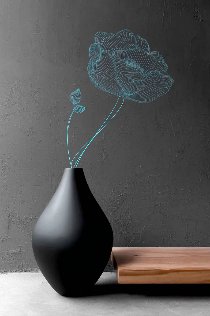 Matte black vessel and low wooden tray against a charcoal wall, with a luminous turquoise line drawing of a flower rising from the vessel.