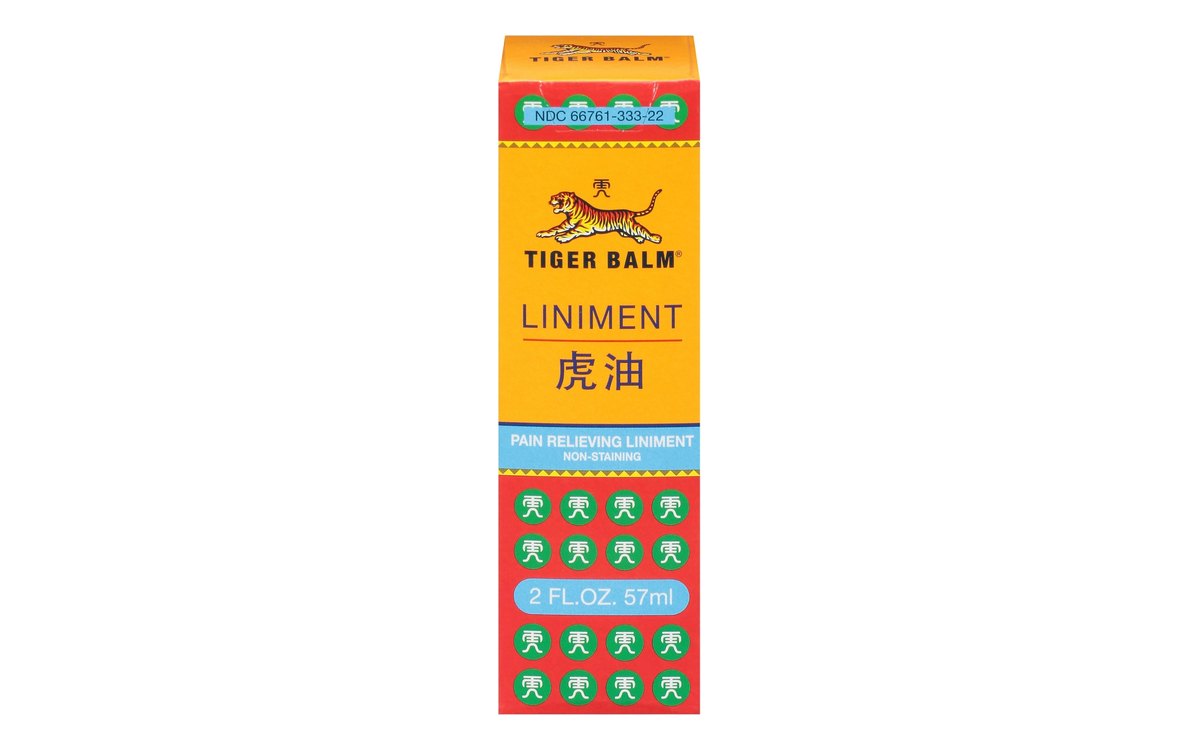 Tiger Balm Liniment carton on white: a tall yellow and red box with a green pattern