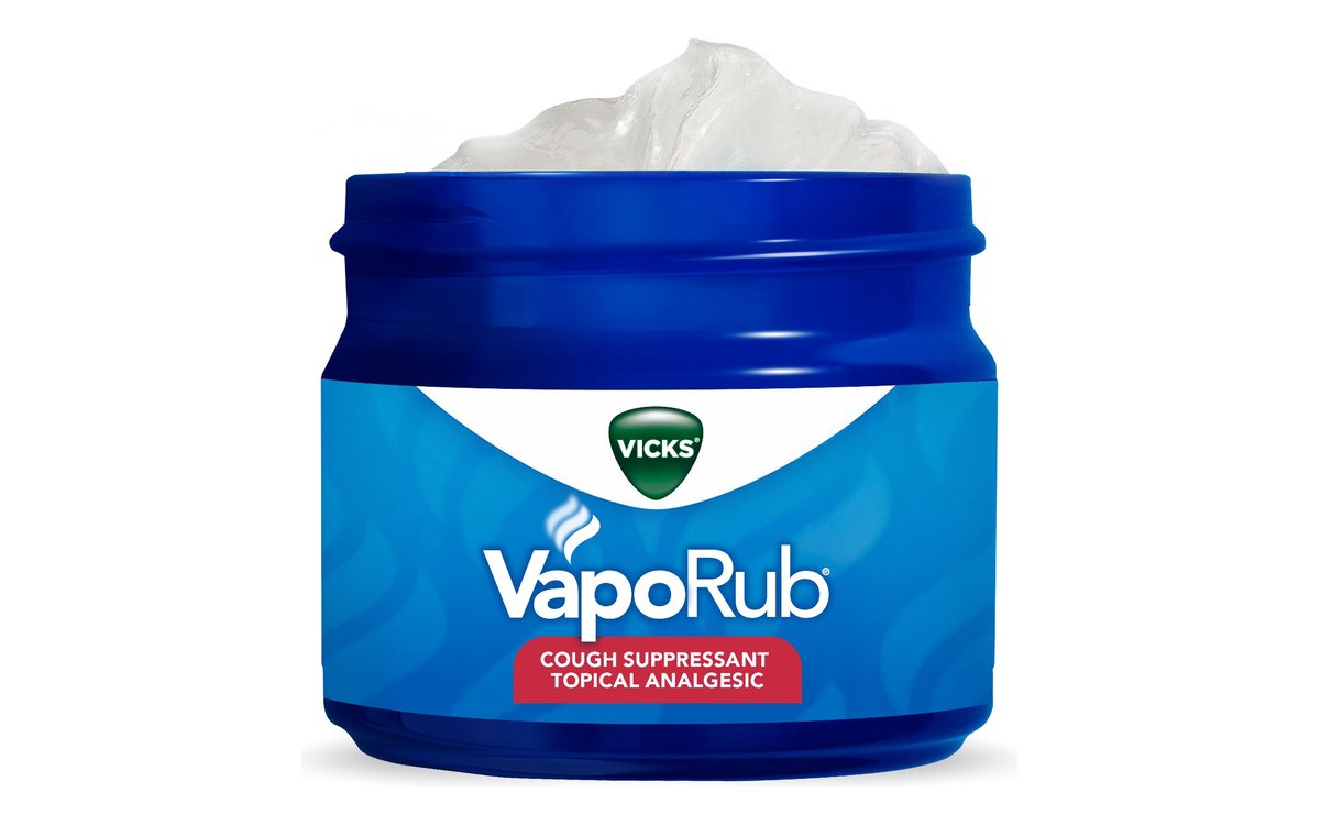 Vicks VapoRub jar on white: a cobalt blue jar with the lid off showing white ointment