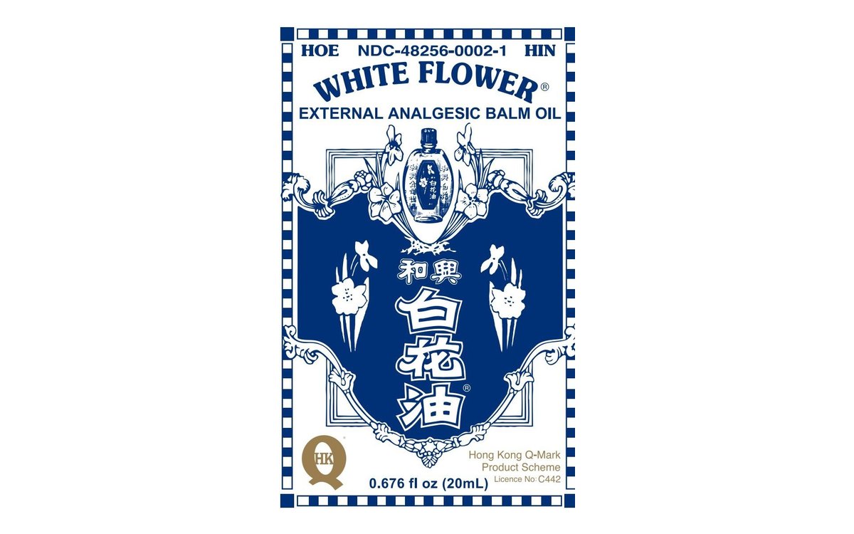 Front panel of the White Flower carton from its filed label: cobalt and white, with a small bottle, lilies and scrollwork around Chinese characters