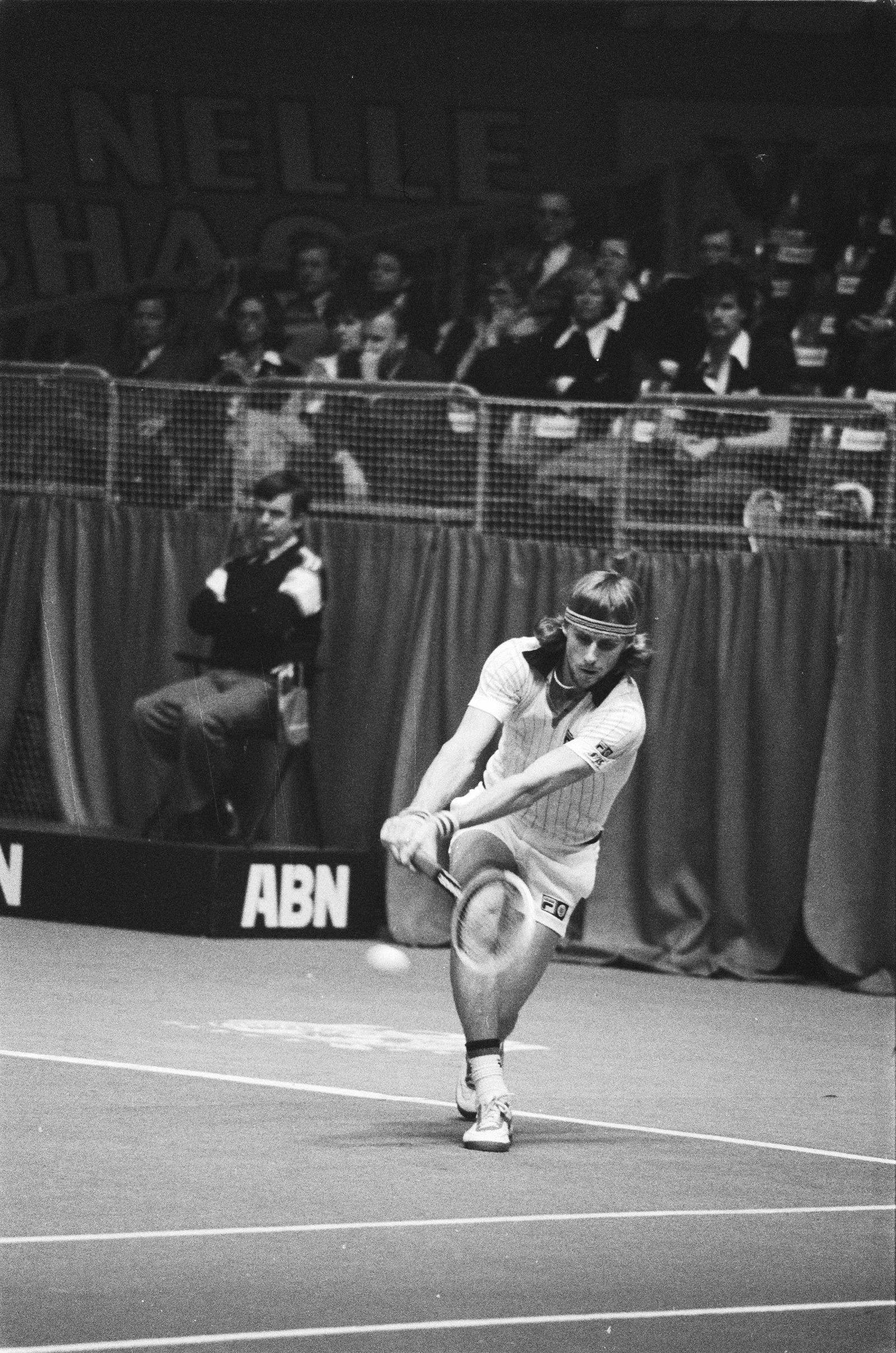 Black-and-white photograph of Björn Borg hitting a two-handed backhand in a striped FILA polo and white shorts.