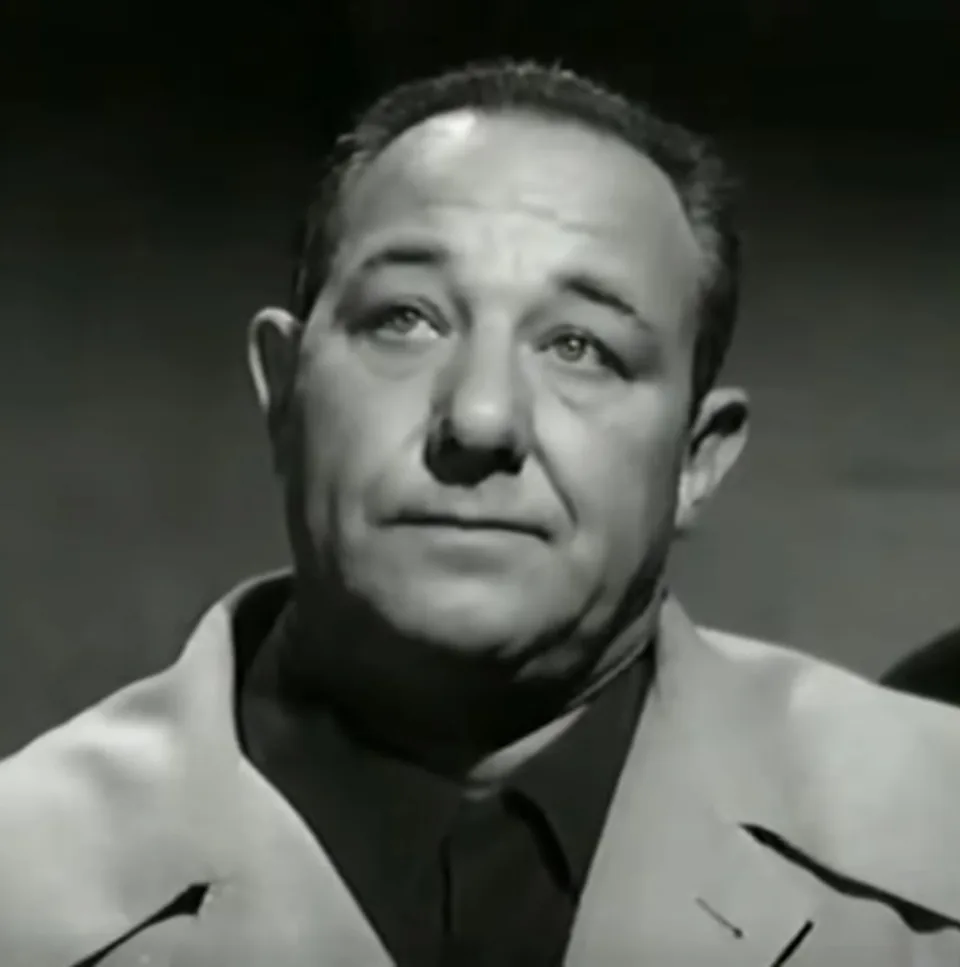 Black-and-white close-up of Alan Reed in a jacket and tie.
