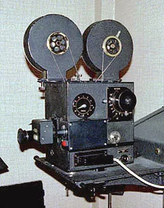 A motion-picture camera with two large film reels mounted on an animation stand.